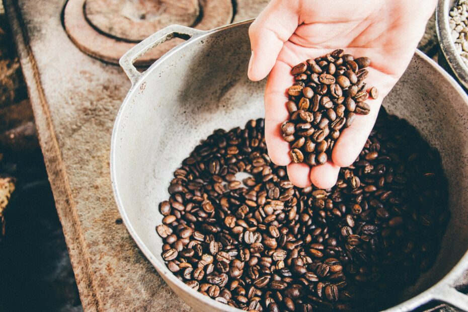 Hand hält Kaffebohnen. Symbolbild für eine nachhaltige Lieferkette